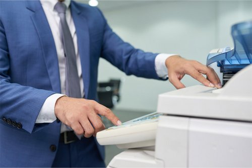 Мужчина сканирует документы в офисе